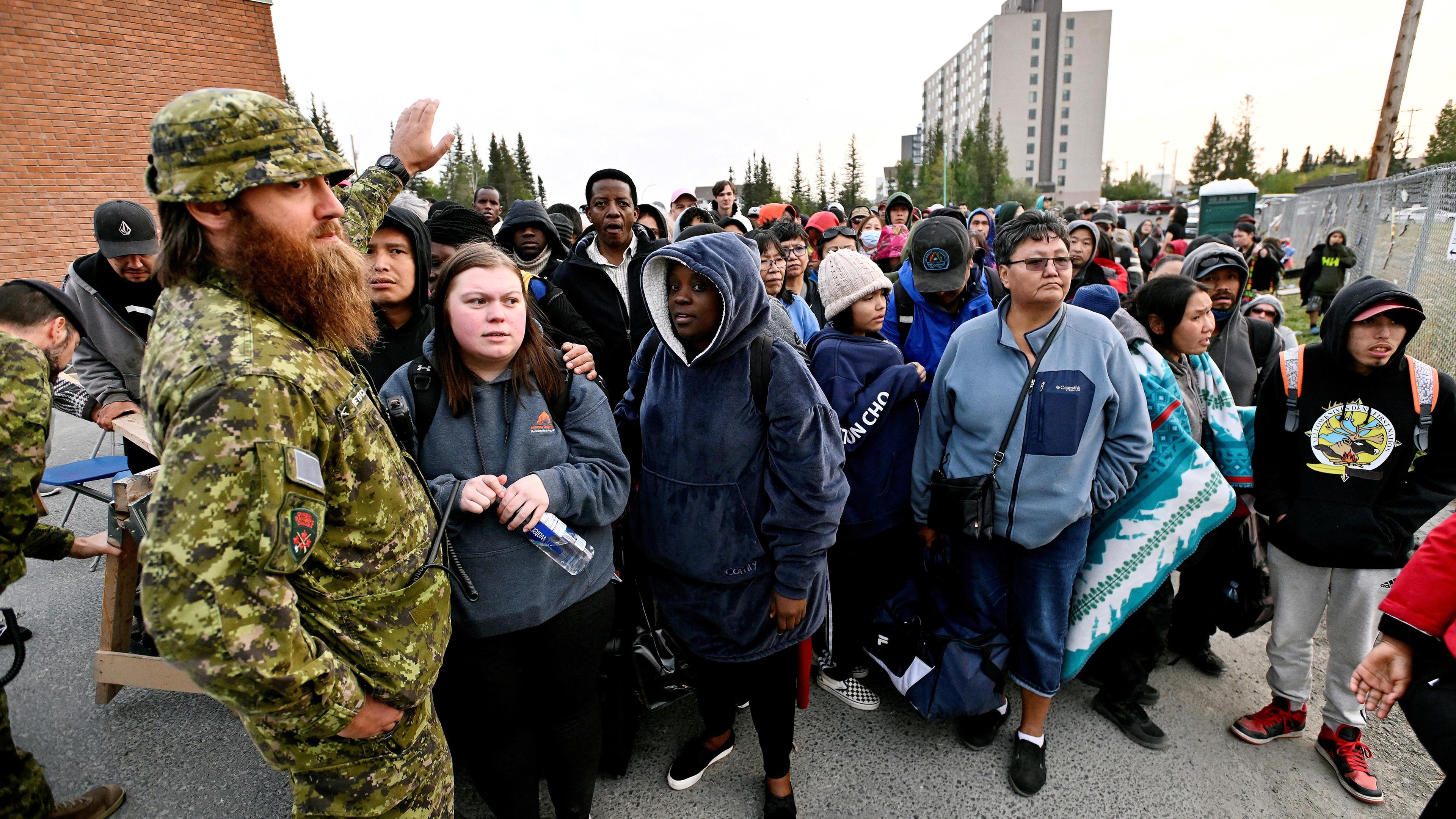 Menschen stehen vor einer örtlichen Schule Schlange, um sich für die Evakuierung anzumelden, da Waldbrände die Stadt Yellowknife, Kanada, in den Nordwest-Territorien bedrohen