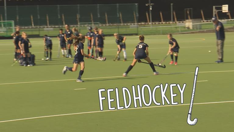 Kinder spielen Feldhockey