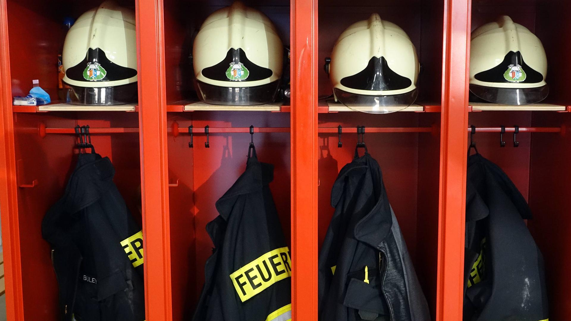 Spinde mit Helmen und Jacken bei der Feuerwehr. 