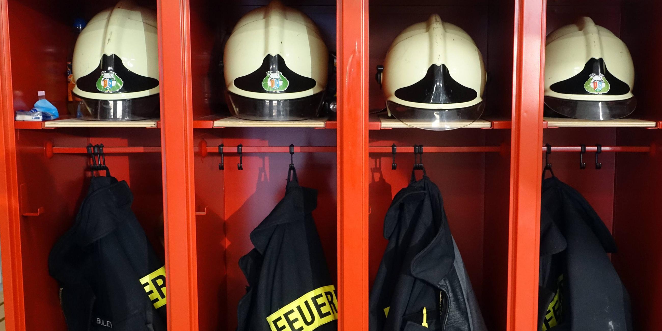 Spinde mit Helmen und Jacken bei der Feuerwehr. 