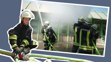 Schülerinnen und Schüler löschen mit Feuerwehrschlauch