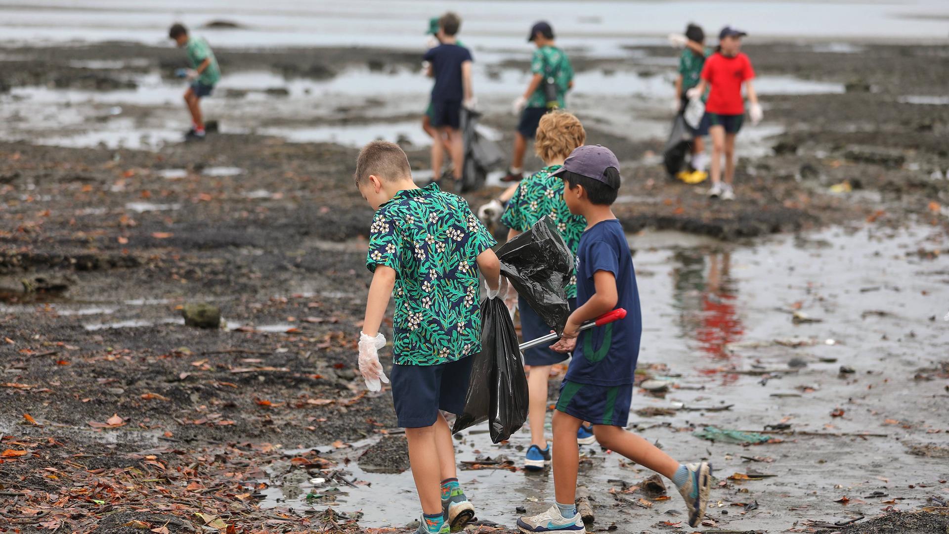Kinder sammeln Müll an einem Strand