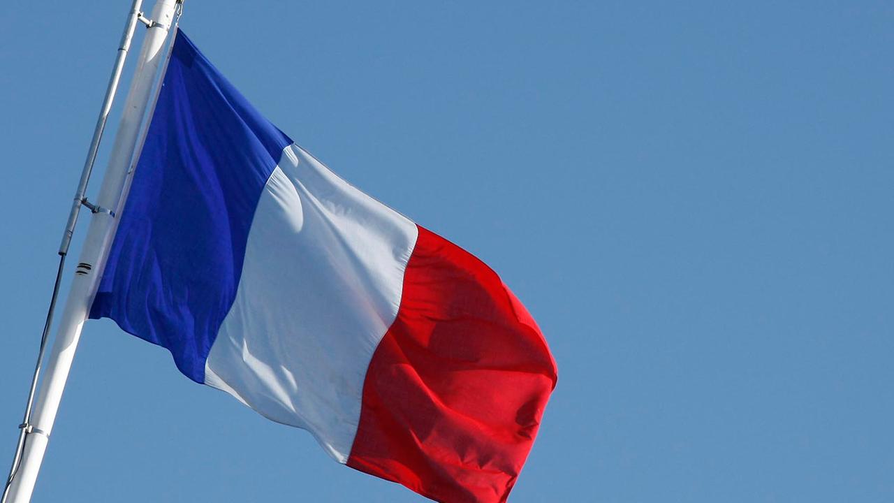 Französische Flagge mit den Farben blau, weiß, rot weht im Wind.