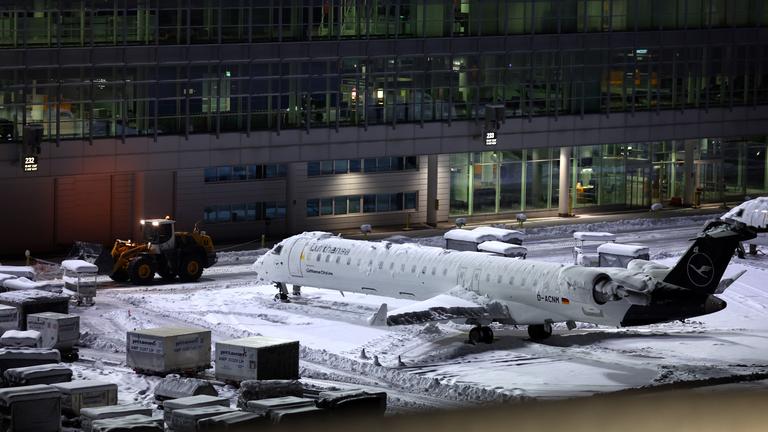 Ein Flugzeug steht auf einer schneebedeckten Wartefläche.