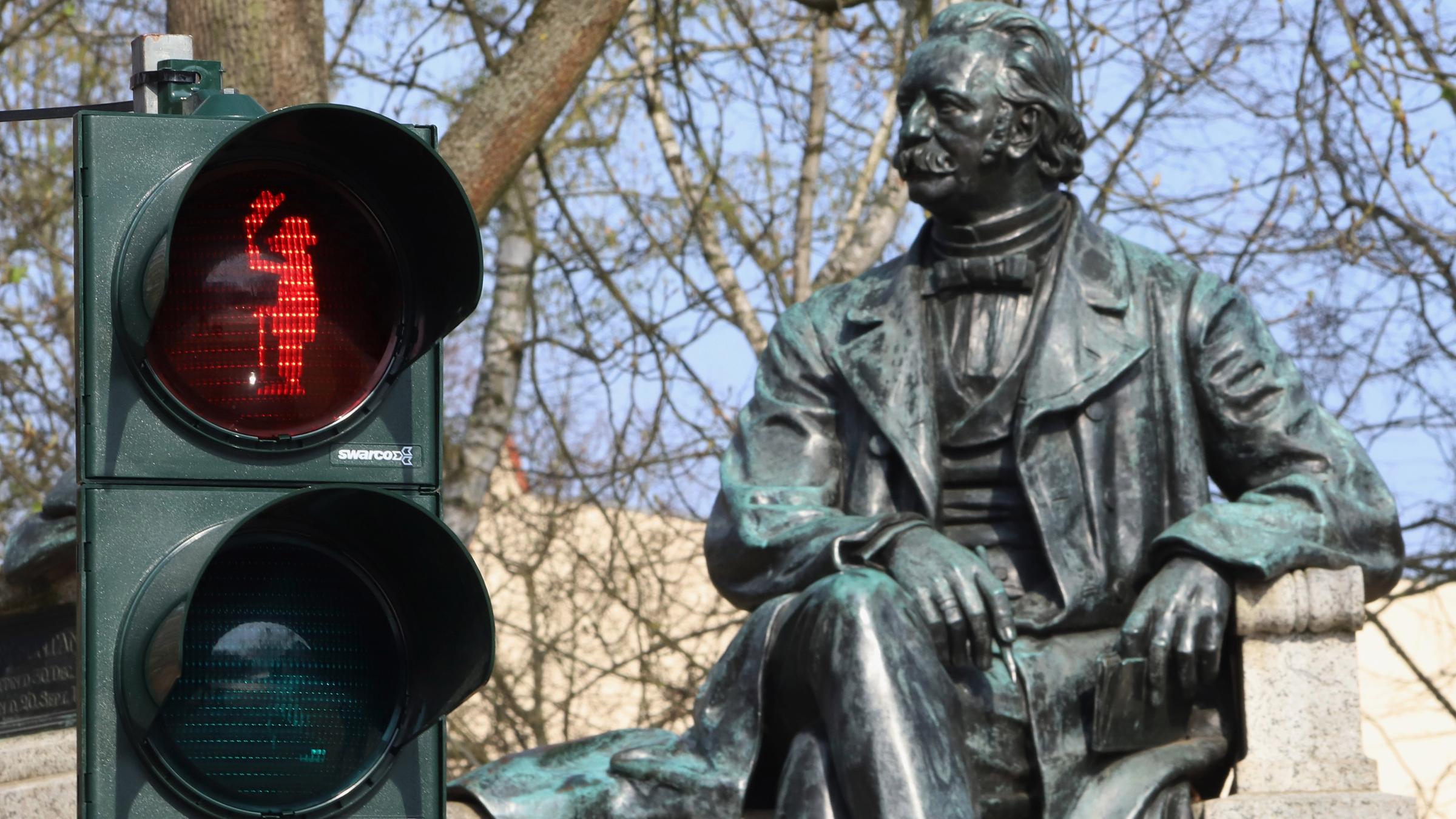rotes Ampelmännchen mit dem Abbild des Schriftstellers Theodor Fontane vor seinem Denkmal