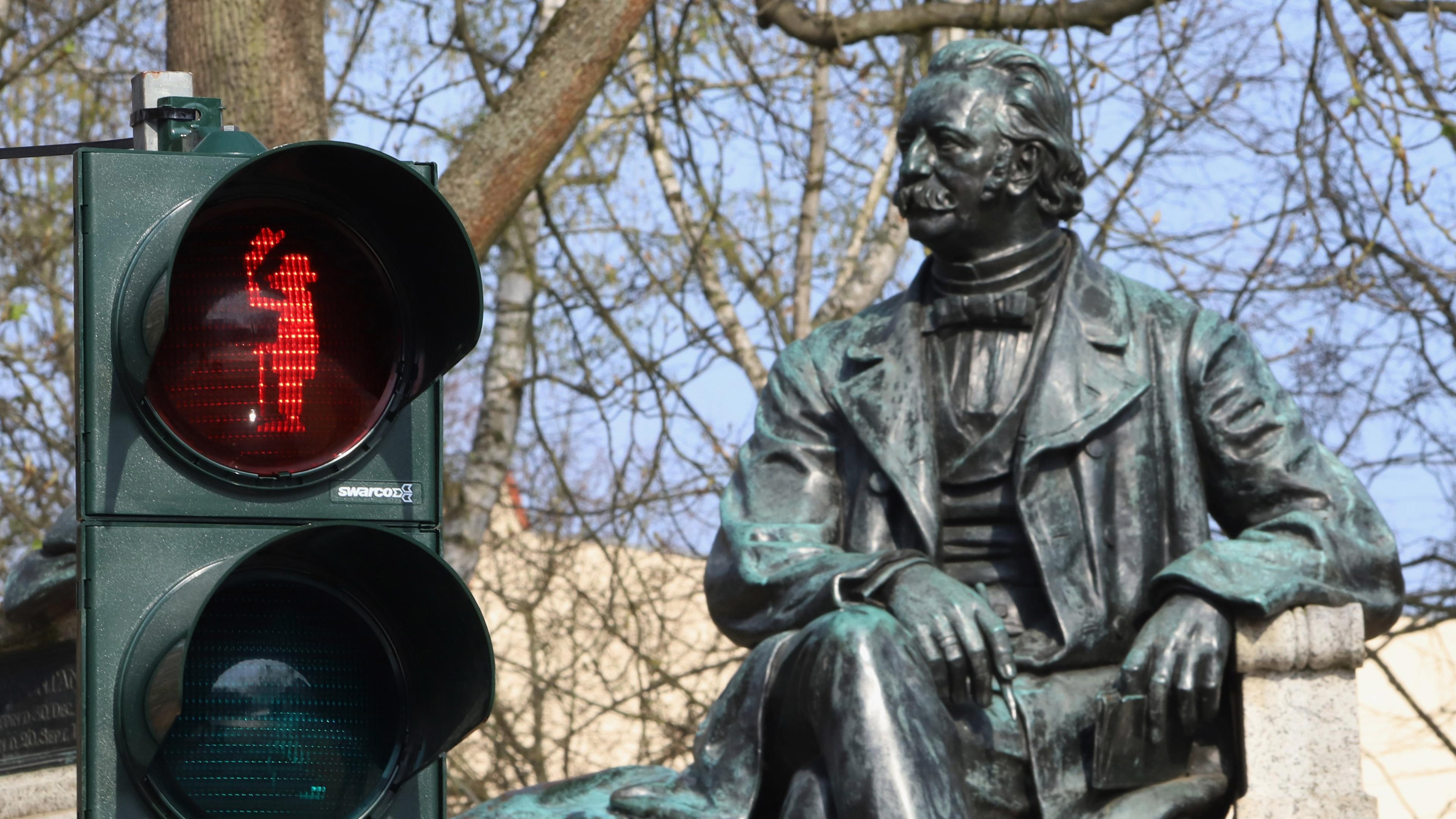 rotes Ampelmännchen mit dem Abbild des Schriftstellers Theodor Fontane vor seinem Denkmal