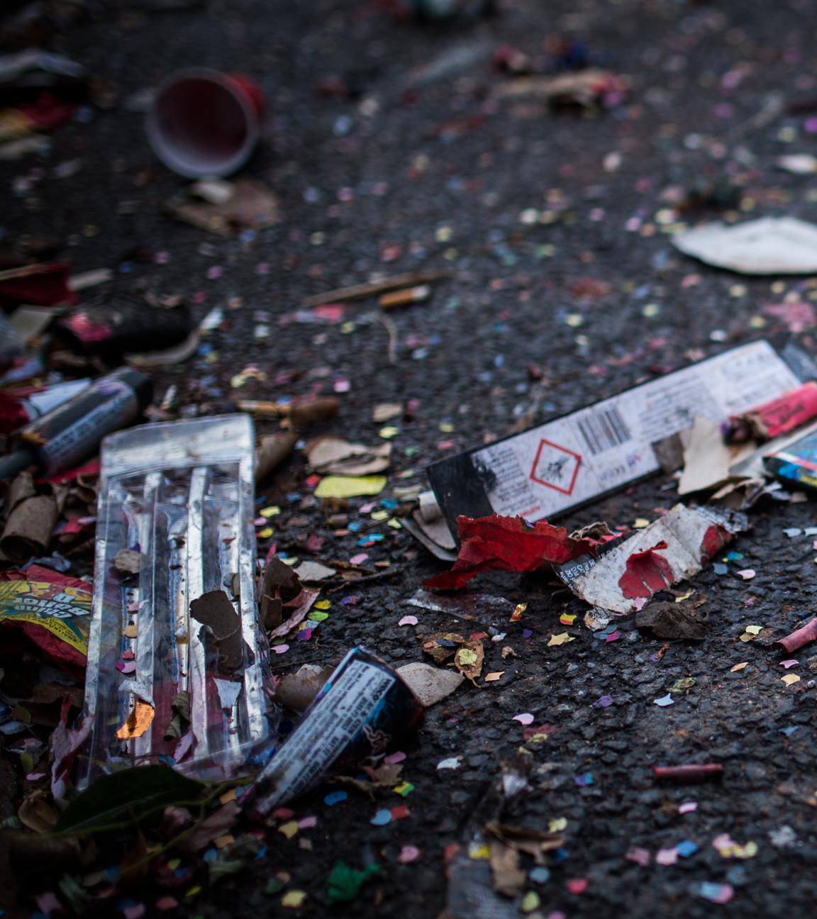 Müll von Silvester-Feuerwerk von Konfetti liegen auf der Straße.