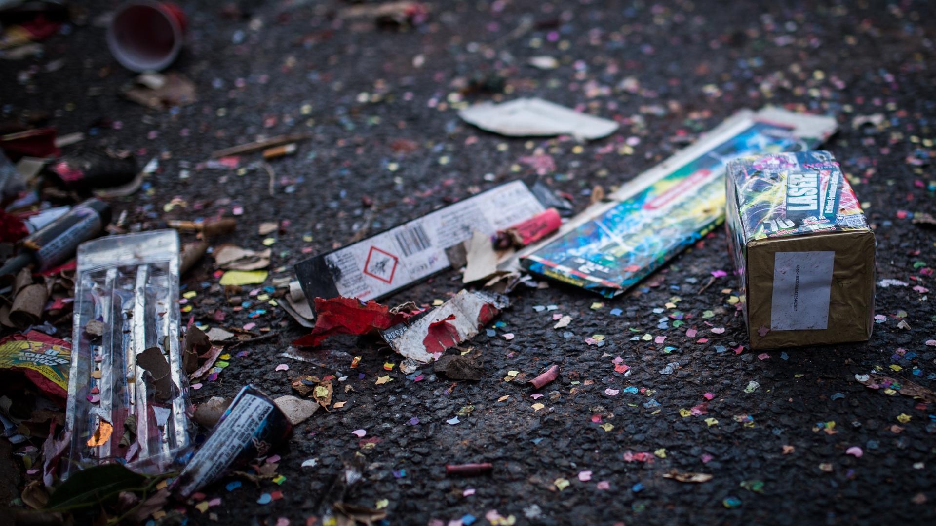 Müll von Silvester-Feuerwerk von Konfetti liegen auf der Straße.