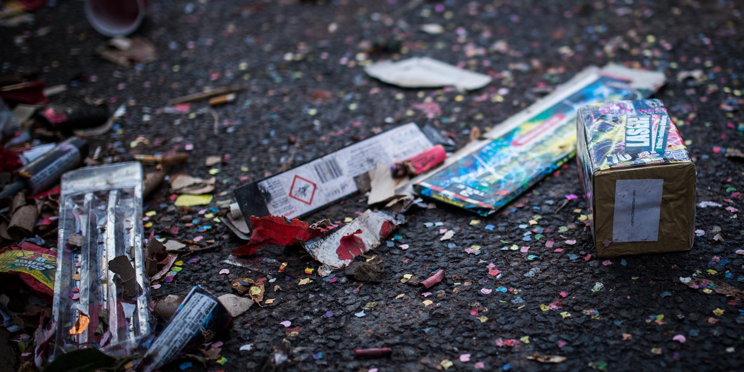 Müll von Silvester-Feuerwerk von Konfetti liegen auf der Straße.