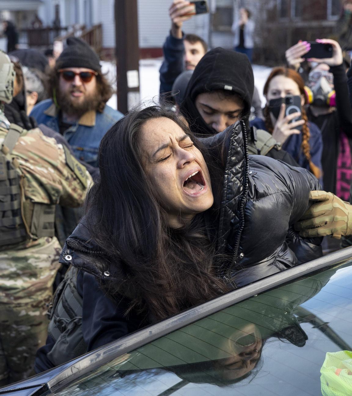ICE-Agenten in Minneapolis, USA, verhaften am 13. Januar 2026 eine Frau, die vermeintlich die Straße blockiert haben soll.