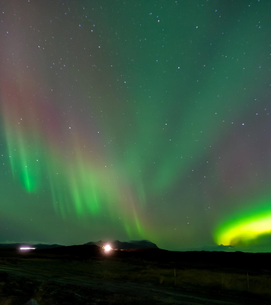 Grüne und rote Polarlichter sowie Sterne am Himmel 