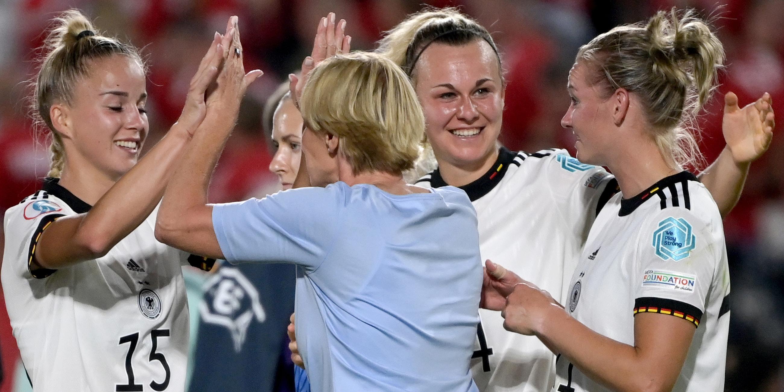 Bundestrainerin Martina Voss-Tecklenburg (2.v.l.) klatscht nach dem 4:0-Sieg mit Deutschlands Giulia Gwinn ab am 08.07.2022 in Brentford, Großbritannien.