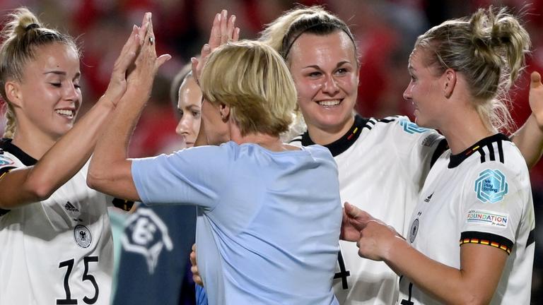 Bundestrainerin Martina Voss-Tecklenburg (2.v.l.) klatscht nach dem 4:0-Sieg mit Deutschlands Giulia Gwinn ab am 08.07.2022 in Brentford, Großbritannien.