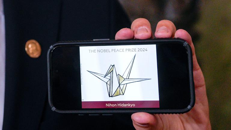 Logo der Aktivistengruppe Nihon Hidankyo auf, die den Preis gewinnt, auf Handbildschirm