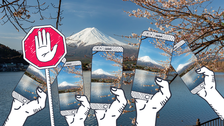 Viele Smartphones in Händen mit Fotos von dem Mount Fuji in Japan mit Stoppschild