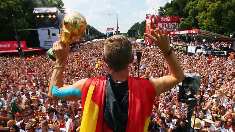 Bastian Schweinsteiger mit dem WM-Pokal vor Tausenden Fans.