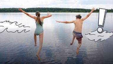 Zwei Jugendliche springen in einen See