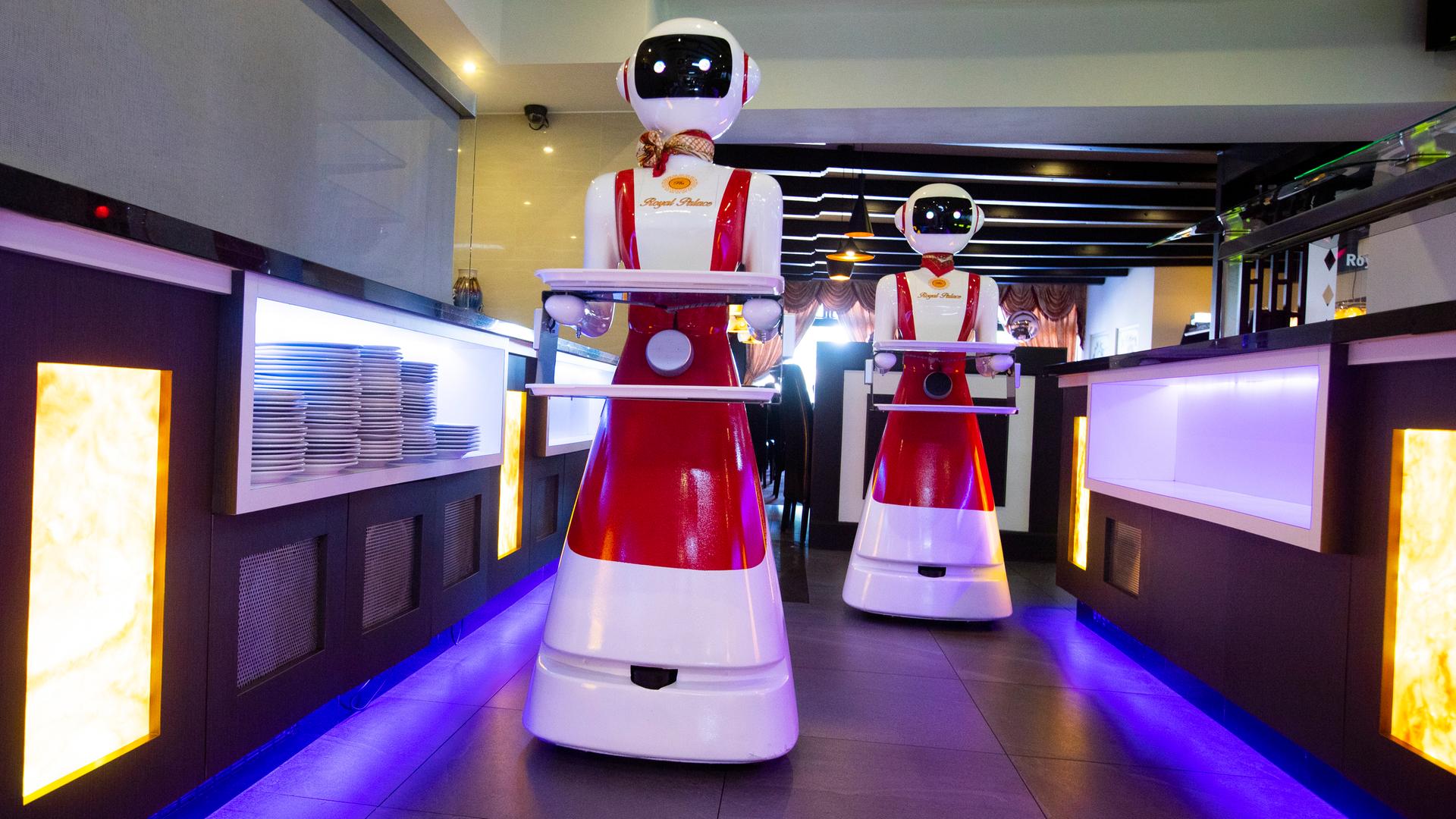 In einem Restaurant servieren Roboter auf Tablets das Essen für die Kunden