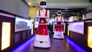 In einem Restaurant servieren Roboter auf Tablets das Essen für die Kunden