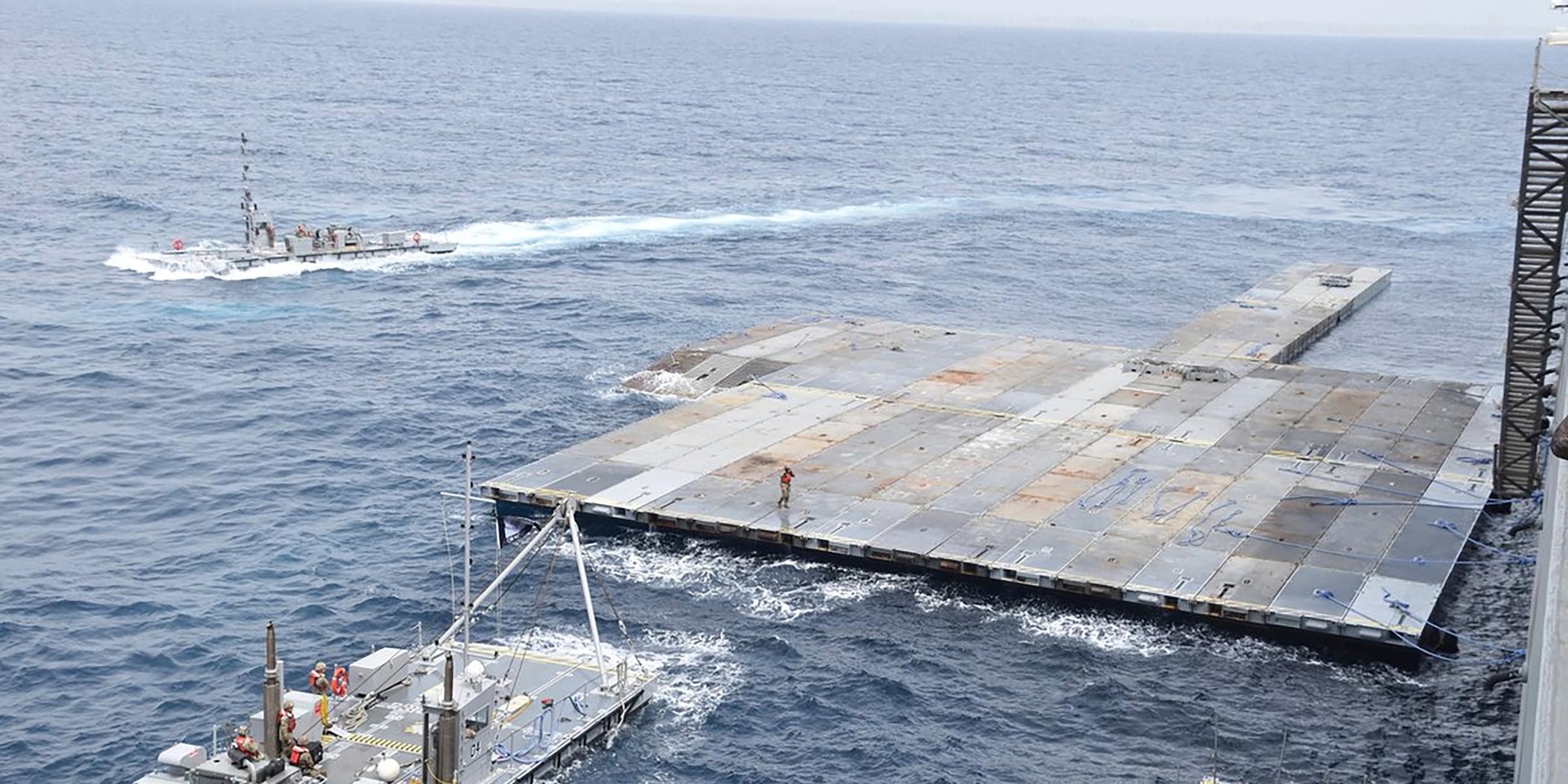 Eine graue Plattform wird im Meer gebaut.