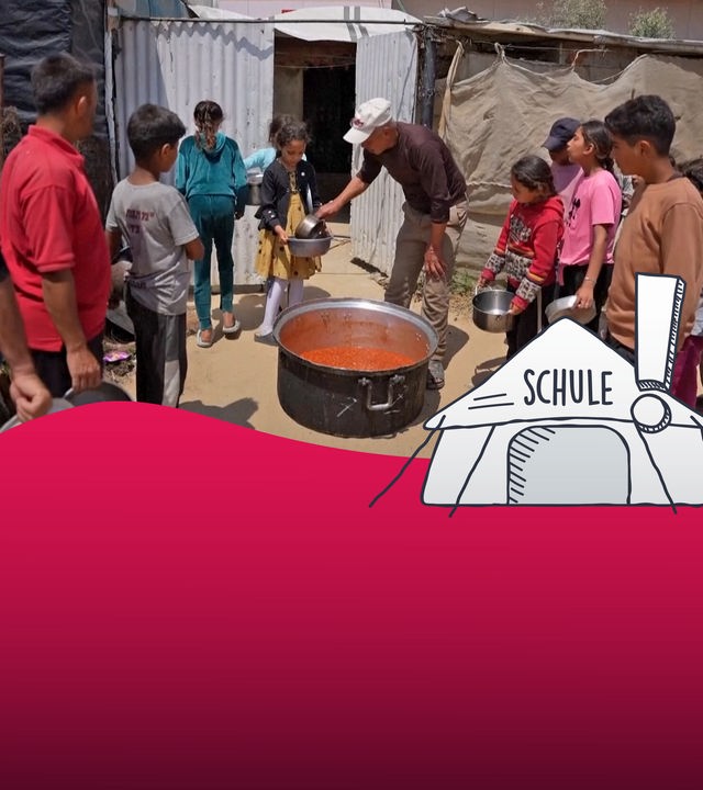 Mehrere Kinder stehen an der Essensausgabe an