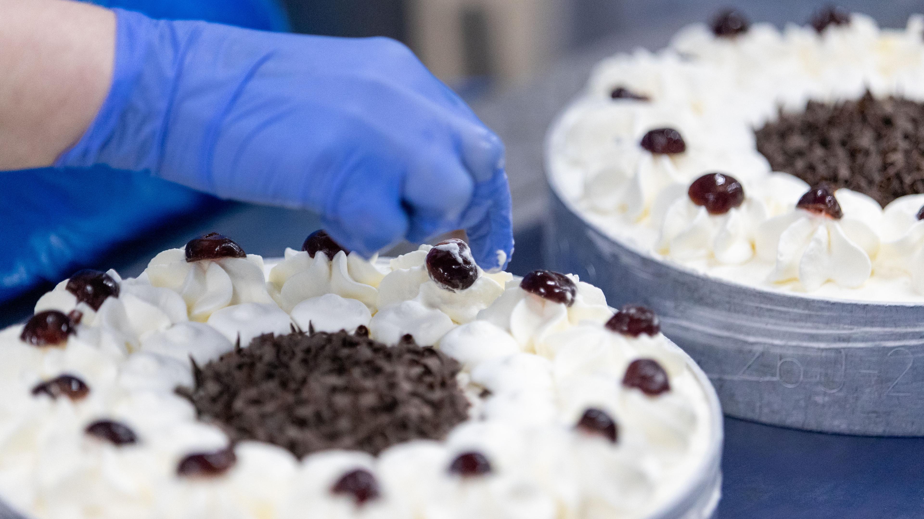 Eine Frau fertigt eine tiefgefrorene Torte an.