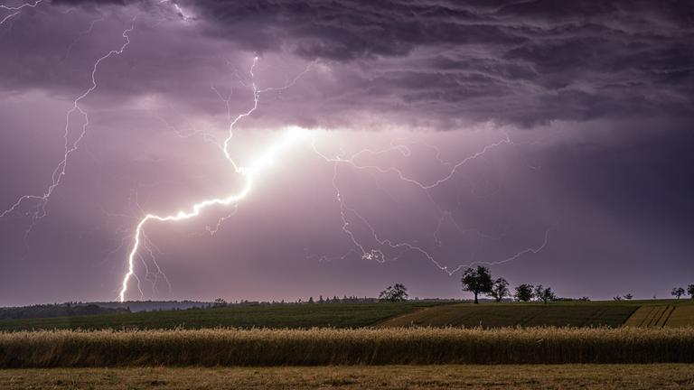 Ein Blitz zuckt bei einem Sommergewitter in der Nacht über den Himmel. Der Deutsche Wetterdienst (DWD) rechnete für Samstag mit weiteren Gewittern. Von den Mittelgebirgen bis zu den Küsten könnten sie gebietsweise kräftig ausfallen. 