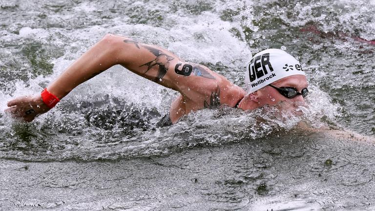 Ein Mann schwimmt im Wasser. 