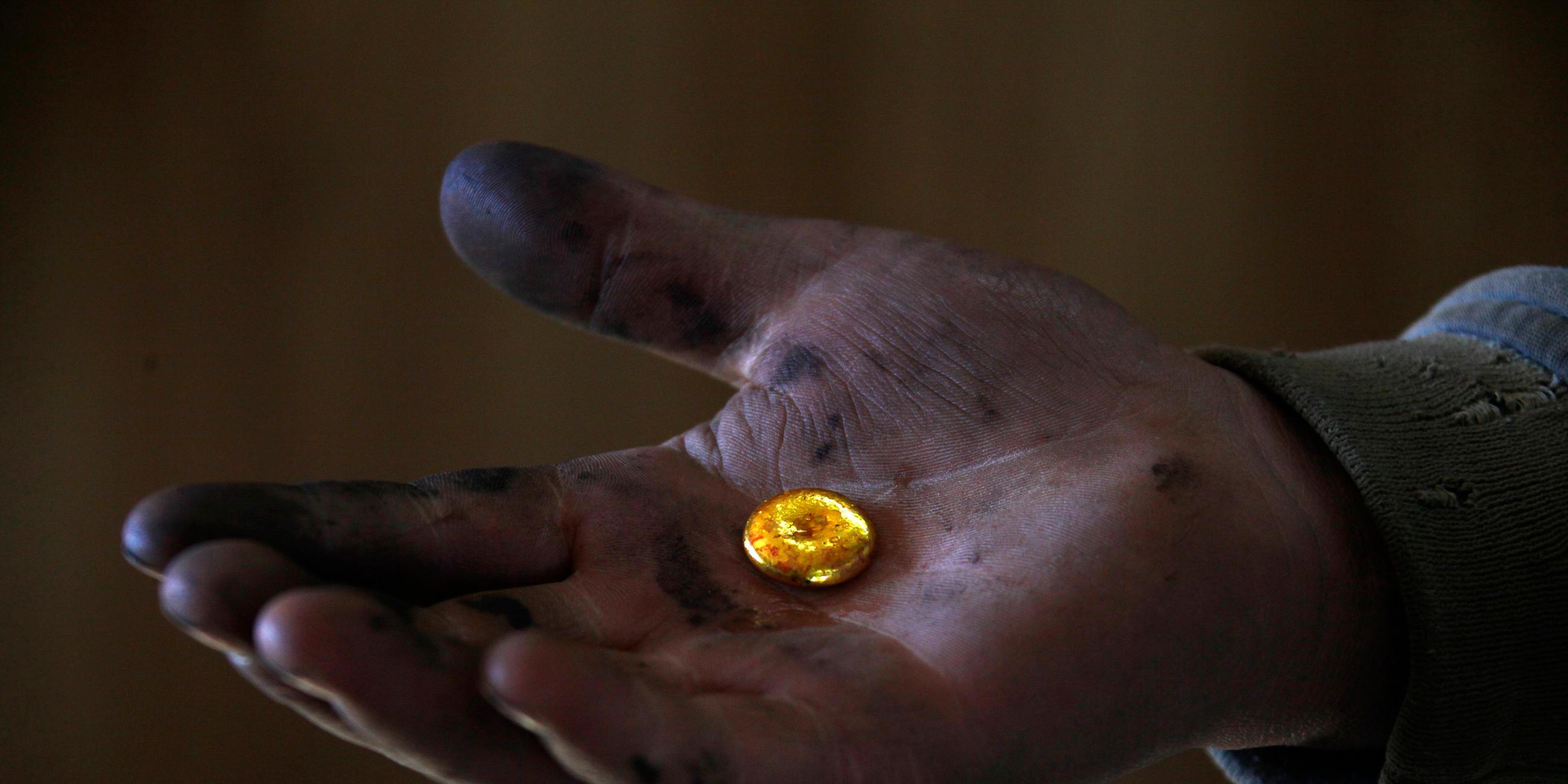 Goldnugget in einer Hand