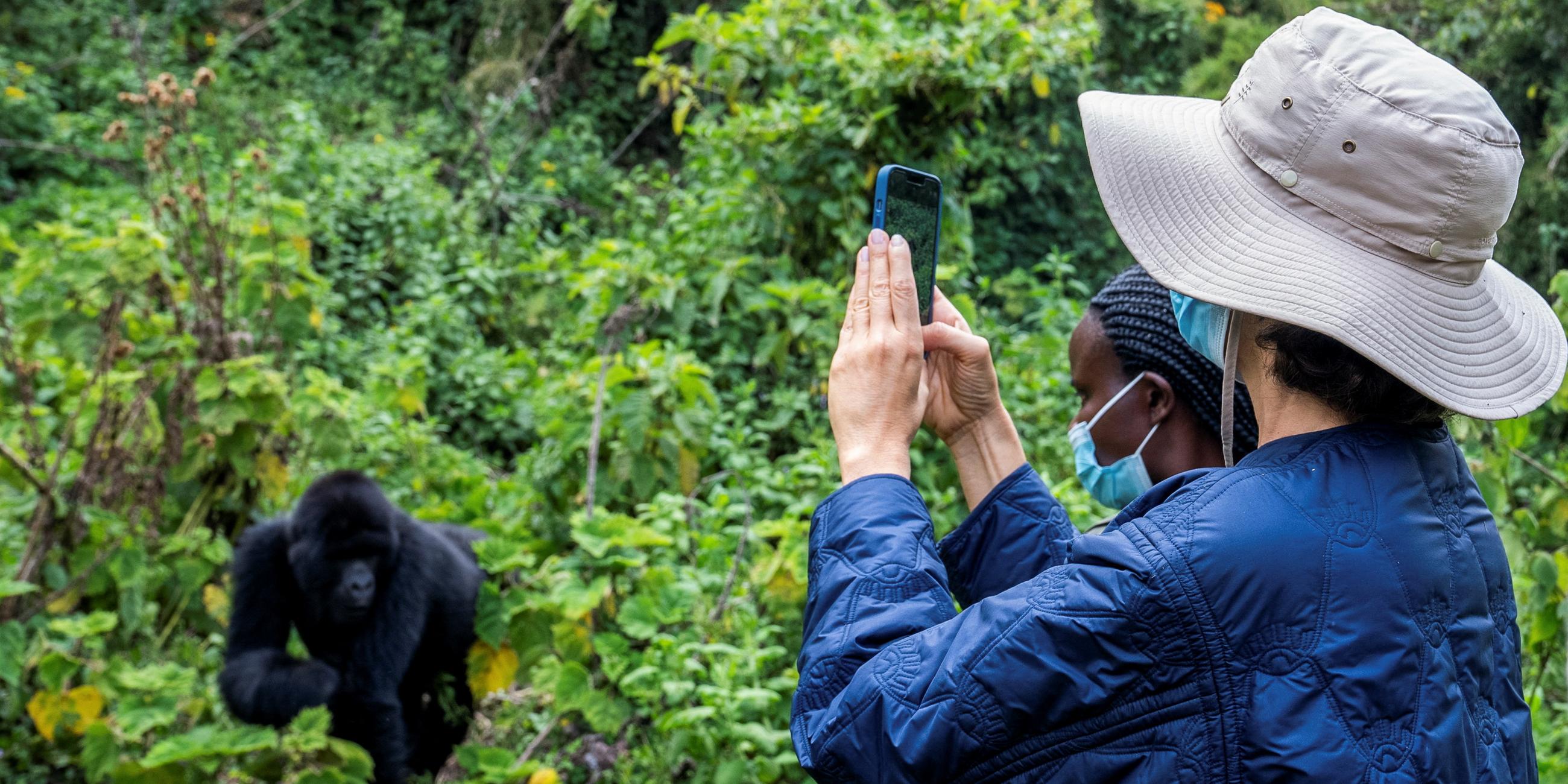 UNESCO's Director-General Audrey Azoulay takes a photo of an endangered high mountain gorilla within