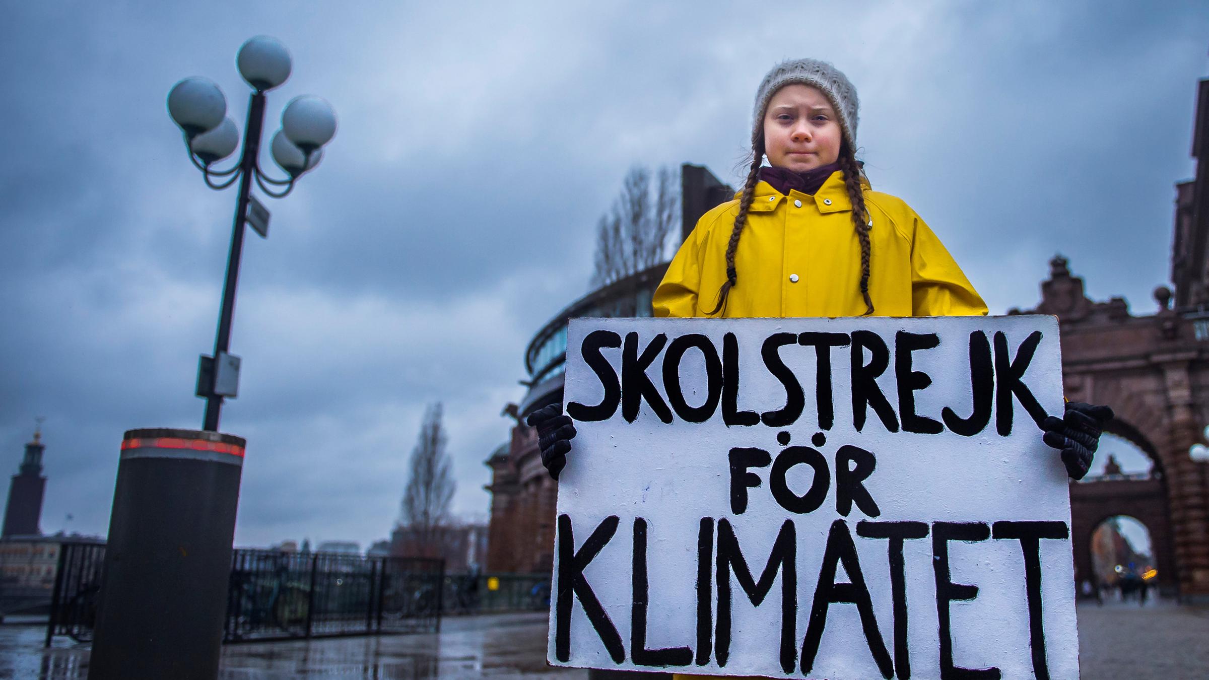 Greta Thunberg steht mit einem Schild vor dem schwedischen Parlament.