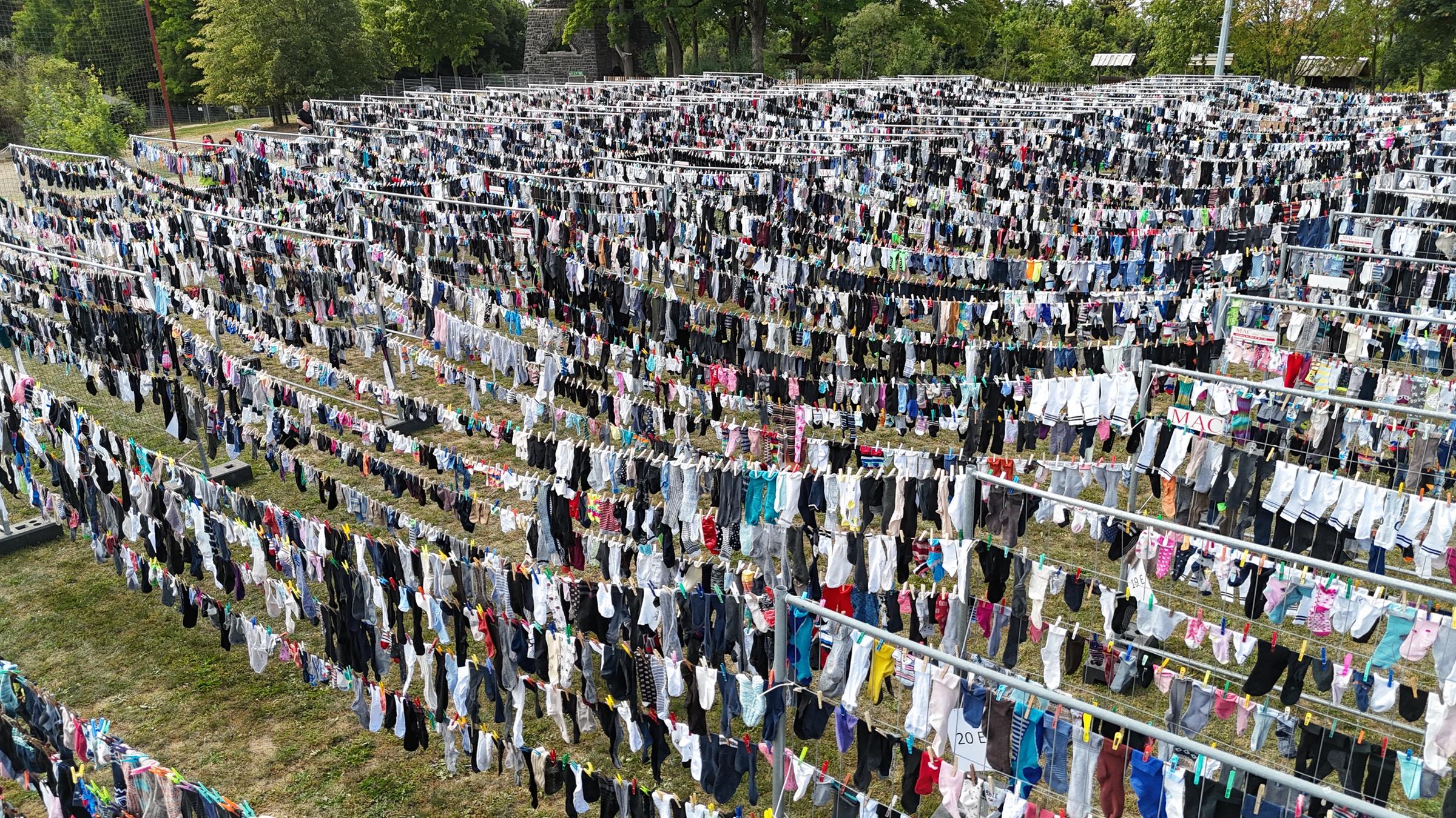 Tausende Socken hängen auf einer Wäscheleine.