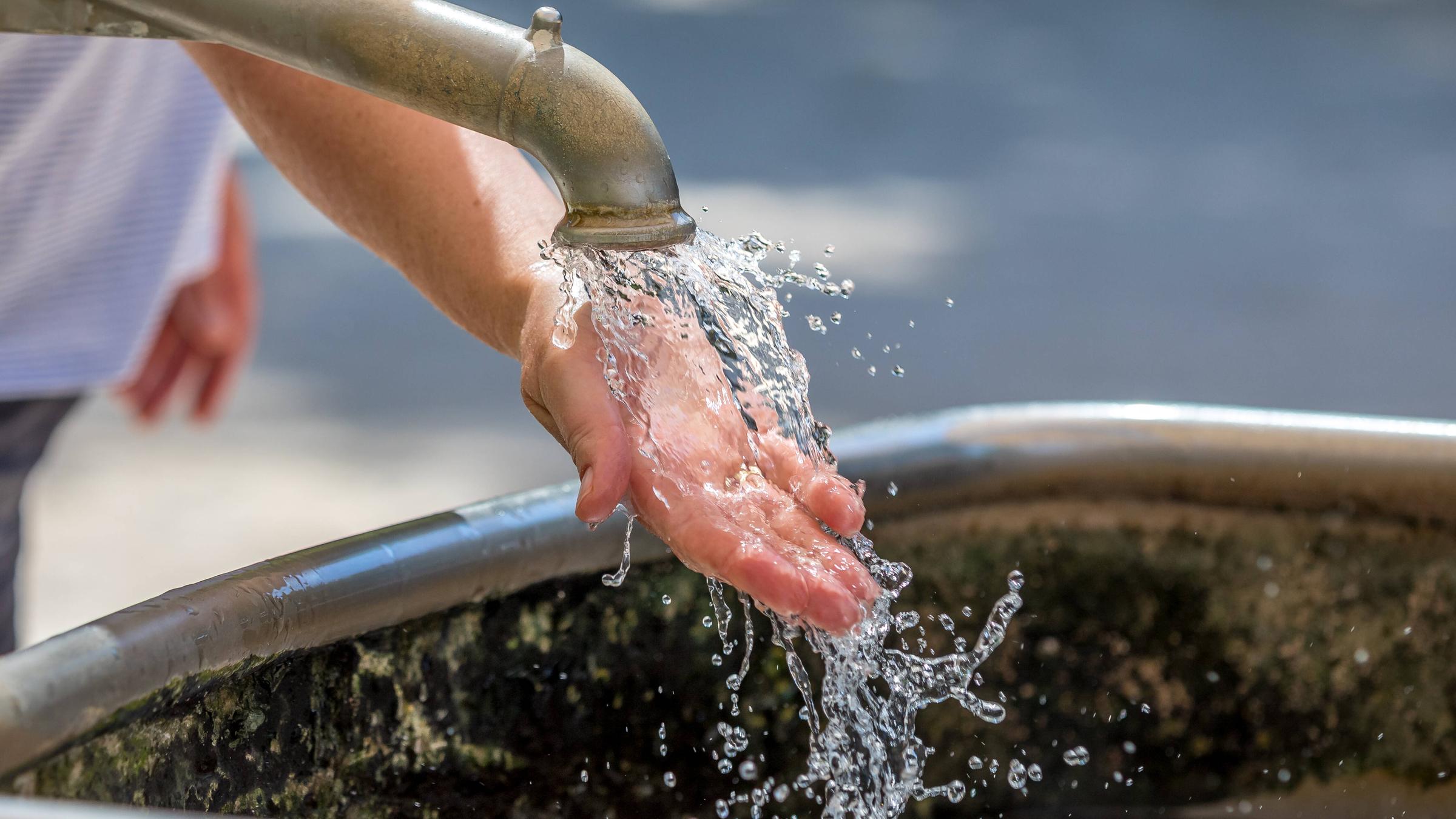 Mädchen halten Hände unters Wasser