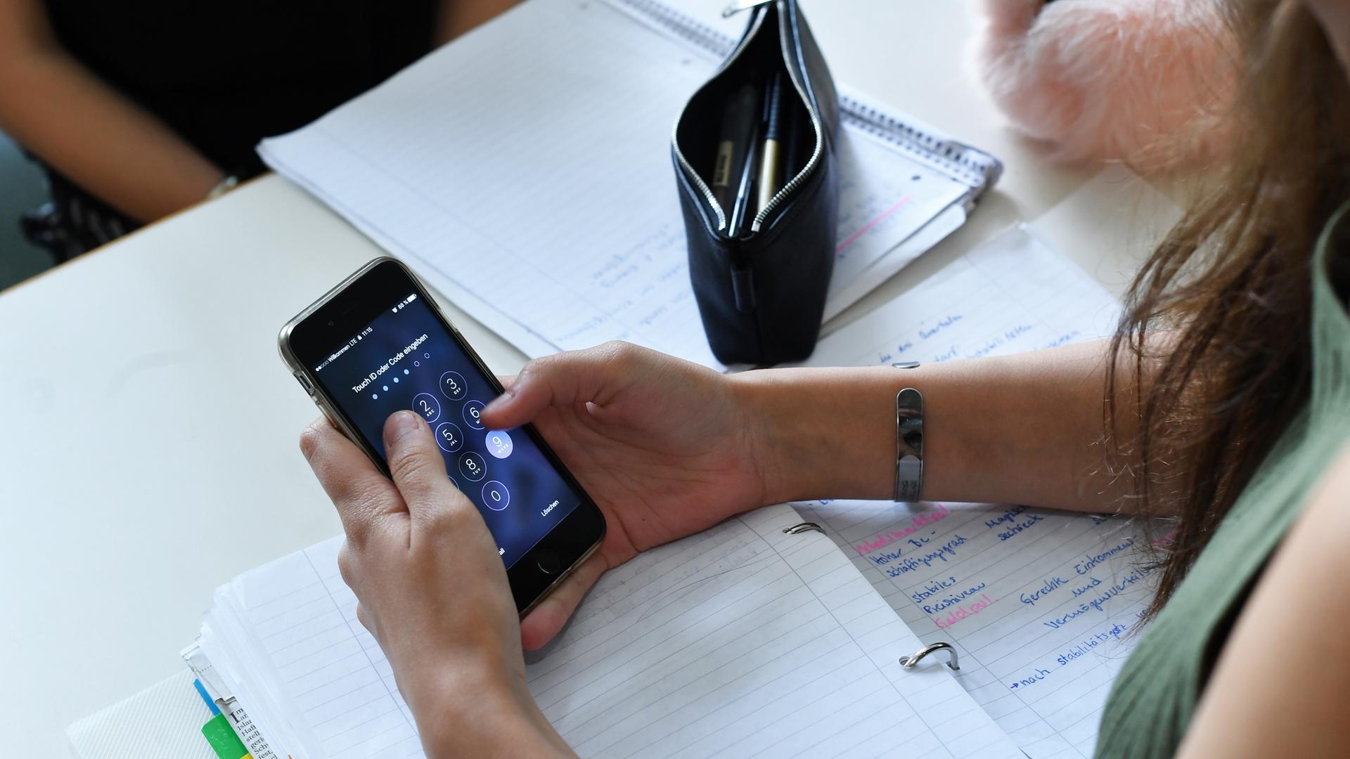 Kind mit Handy im Unterricht. 