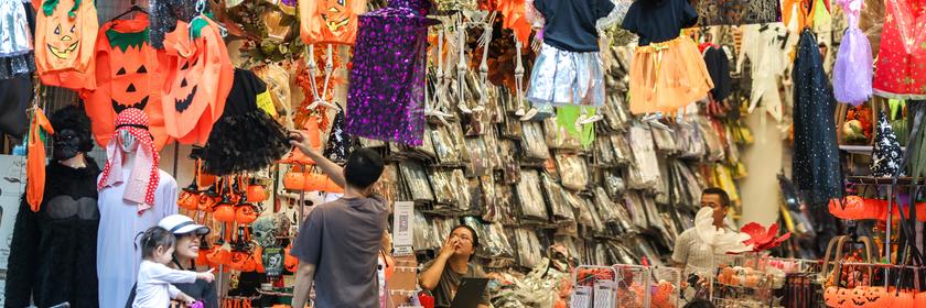 In Hanoi wird am Freitag ordentlich für Halloween vorbereitet. Dafür verkauft ein Mann Kostüme an einem Stand.
