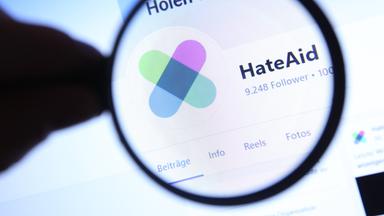 Auf einem Smartphone und einem Laptop wurde die Facebook-Seite von HateAid, der Beratungsstelle für Betroffene von Online-Hassrede und Hasskommentaren, aufgerufen