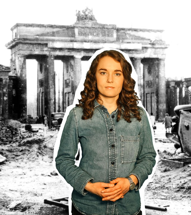 Reporterin Lotte vor einer Schwarz-Weiß-Fotografie des im Zweiten Weltkrieg zerstörten Brandenburger Tors.