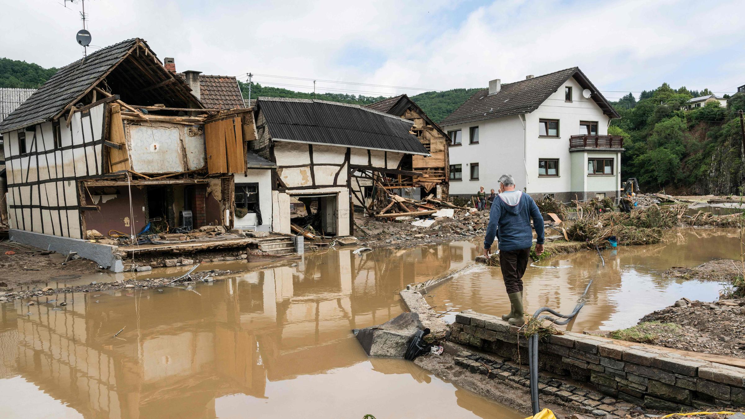 Ein Mann läuft durch das vom Hochwasser zerstörte Gebiet