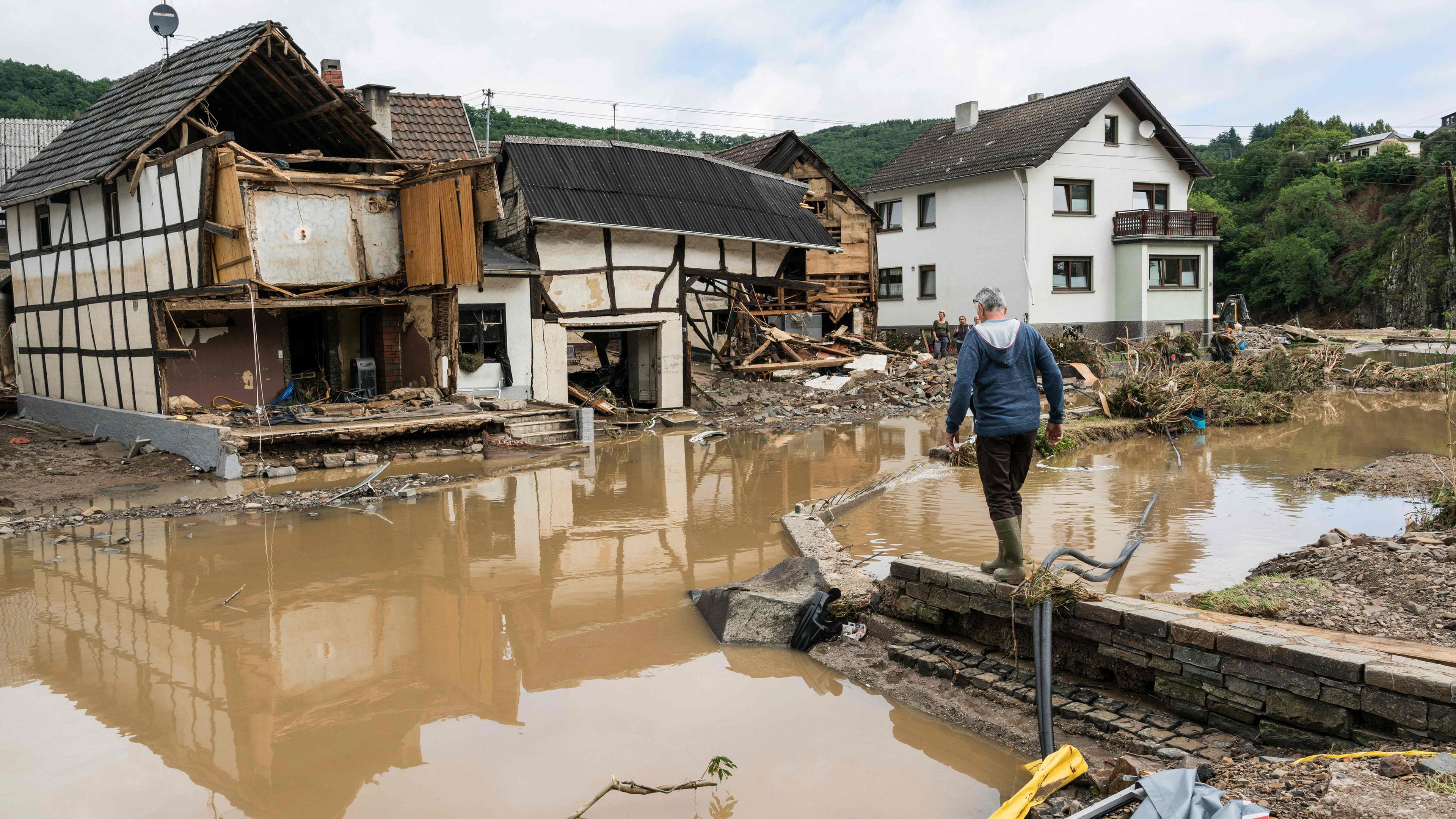 Ein Mann läuft durch das vom Hochwasser zerstörte Gebiet