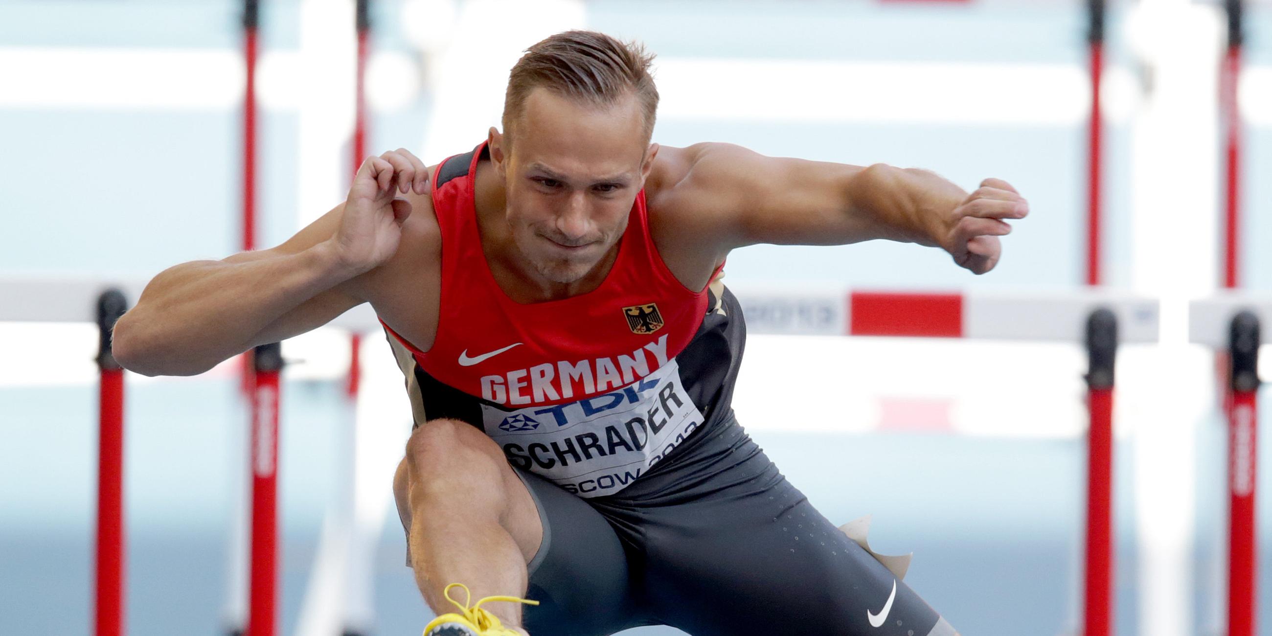 Ein Leichtathlet läuft über eine Hürde
