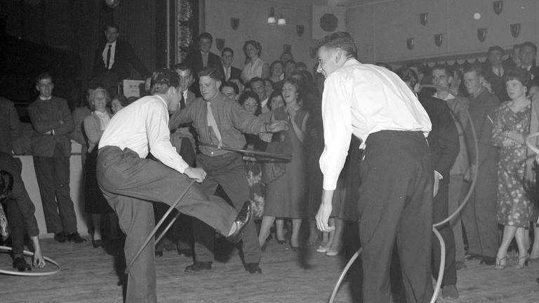 Männer tanzen Hula Hoop 1958 