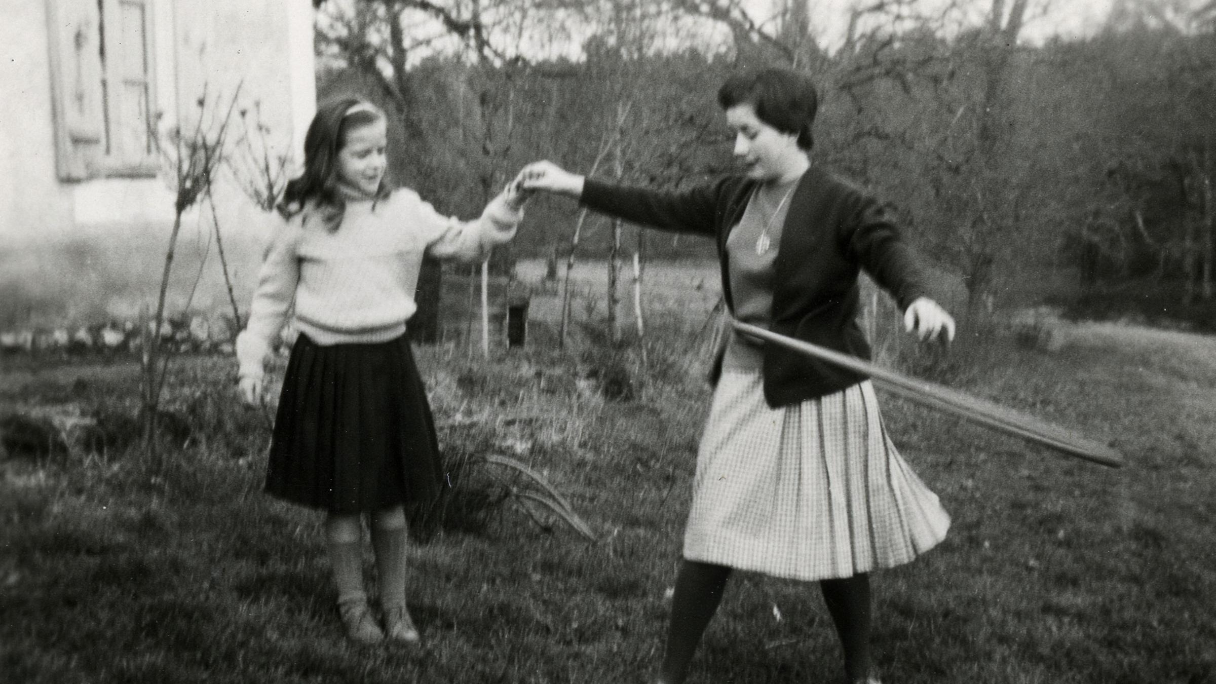 Mädchen mit Mutter, die Hula Hoop macht 