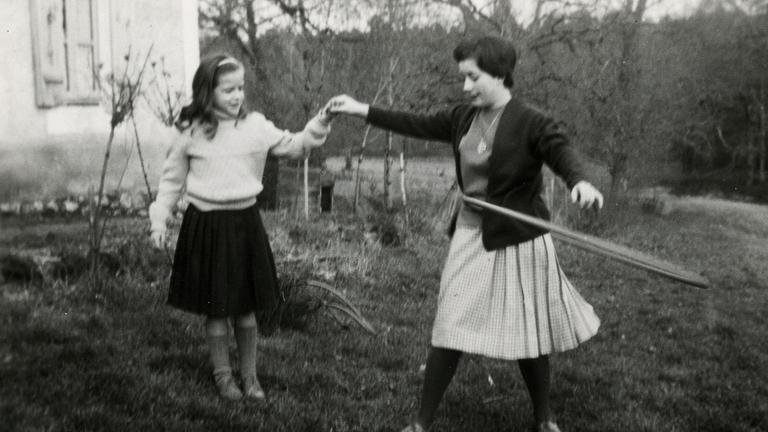 Mädchen mit Mutter, die Hula Hoop macht 