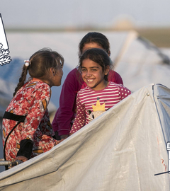 Kinder in einem Flüchtlingscamp mit Grafiken von Essen, Wasser, Medizin und Hilfslieferung