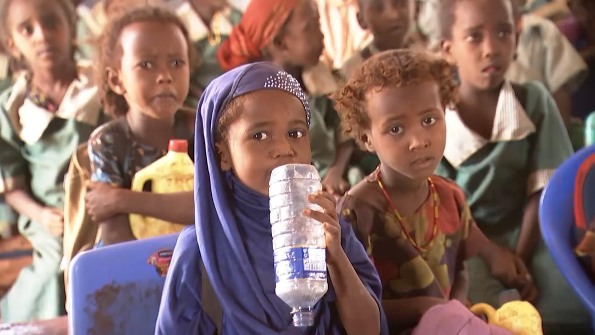 Kinder in Kenia mit einer leeren Wasserflasche