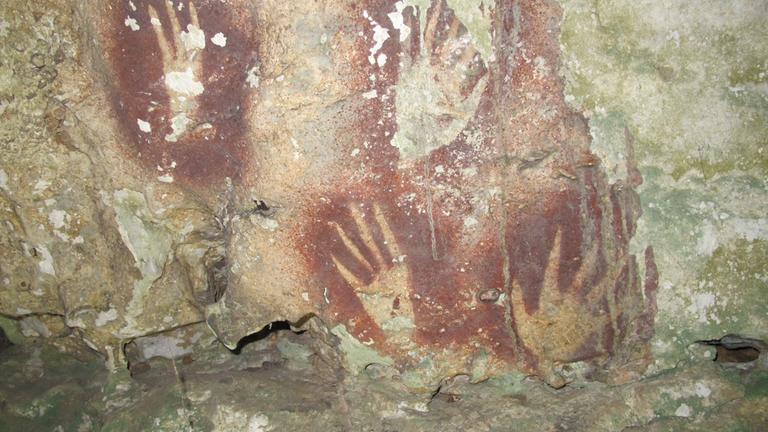 Dieses undatierte Bild, das von Maxime Aubert zur Verfügung gestellt wurde, zeigt Handabdrücke mit zugespitzten Fingerspitzen in der Maros-Region von Sulawesi, Indonesien.