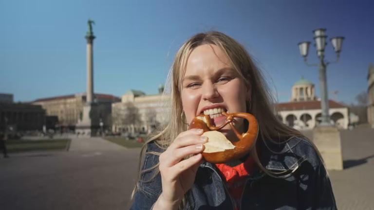 Reporterin Isabelle beißt in eine Breze