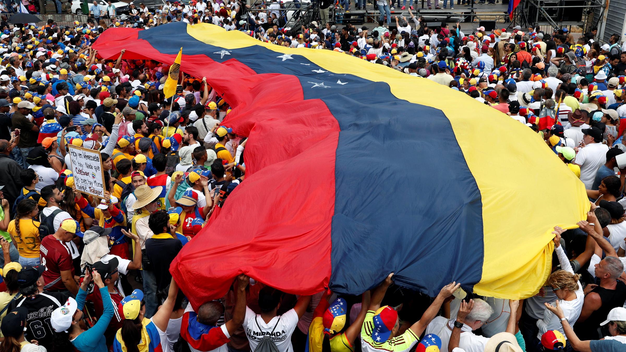 Demonstranten mit einer Flagge von Venezuela. 