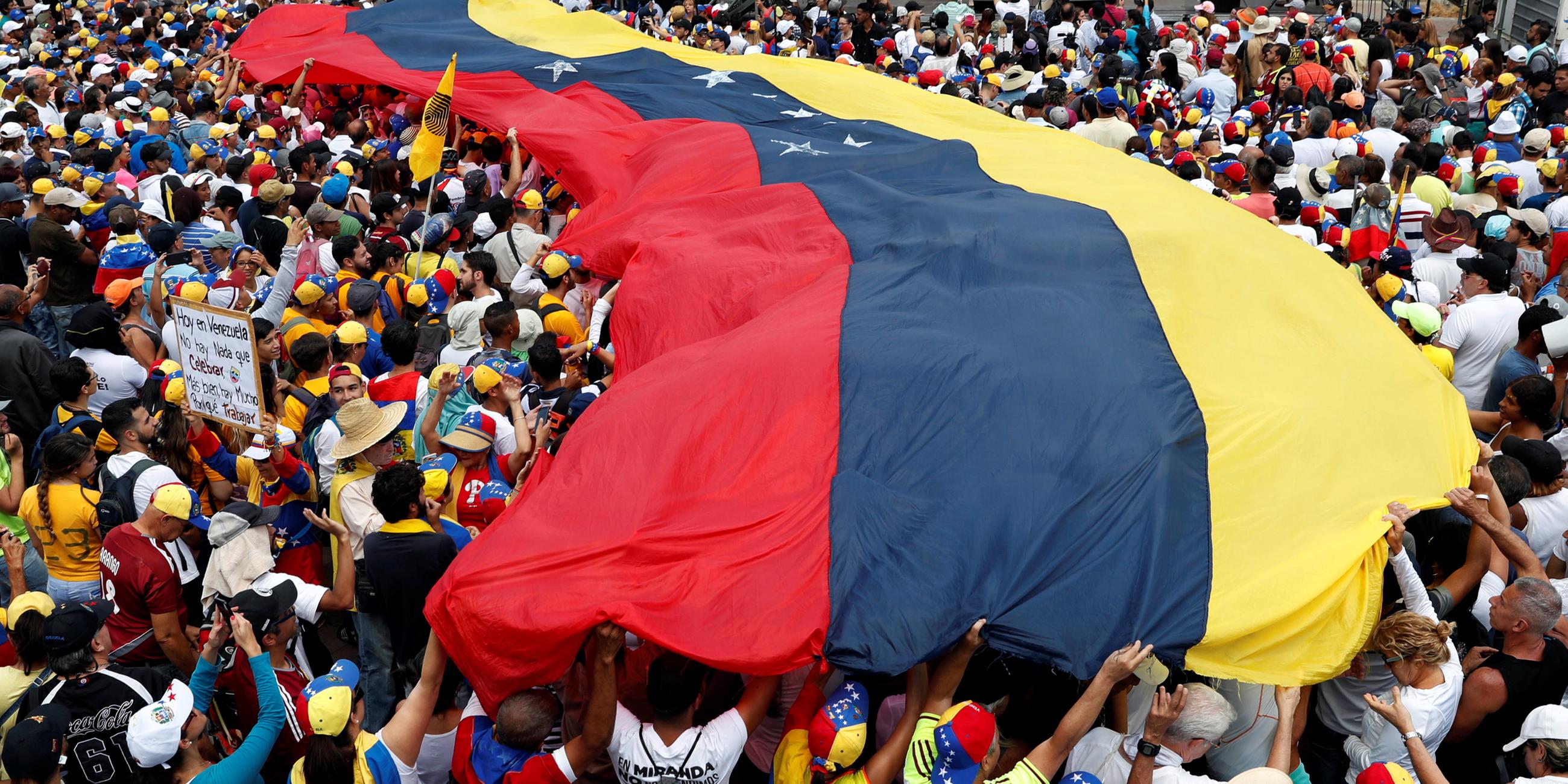 Demonstranten mit einer Flagge von Venezuela. 