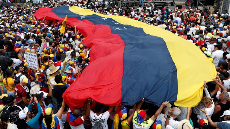 Demonstranten mit einer Flagge von Venezuela. 